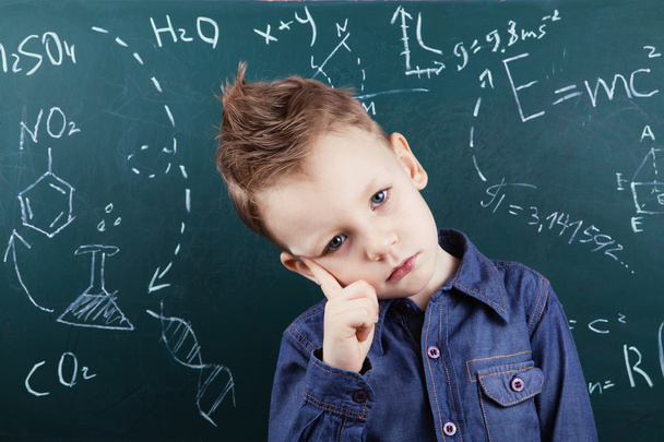 Маленький хлопчик біля дошки з формулами
 - Фото, зображення
