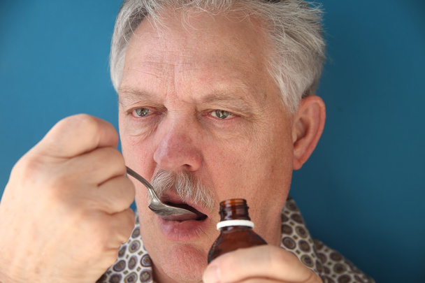 Hombre mayor enfermo toma medicina líquida
 - Foto, imagen