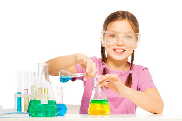 Young schoolgirl mixing blue and yellow reactants - Foto, Bild