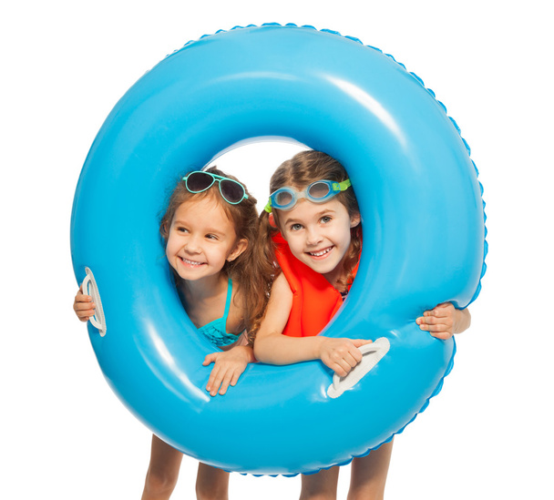 girls looking out big blue rubber ring - 写真・画像
