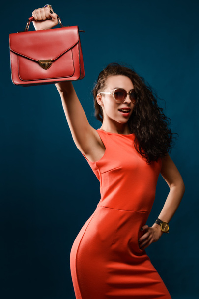 Mutlu kız kırmızı elbise holding çanta onun Merkez over - Fotoğraf, Görsel