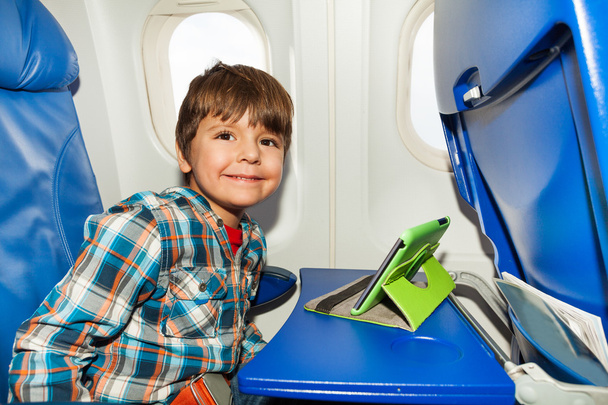 Little boy in airplane chair play tablet pc - Valokuva, kuva
