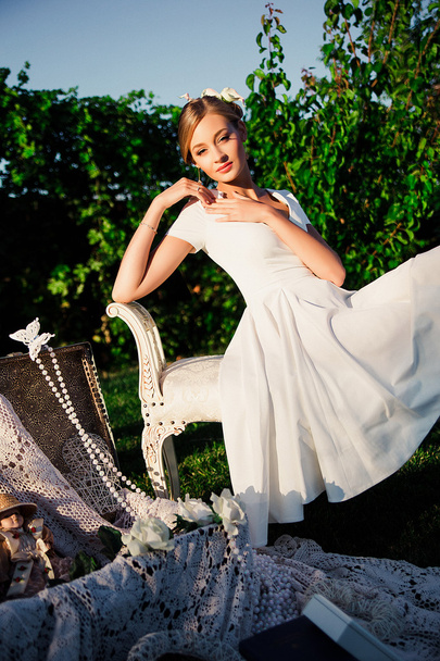 Beautiful romantic woman in light dress posing in a blooming gar - Foto, immagini