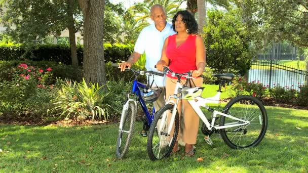 Ethnic senior couple keeping fit on bicycles - Footage, Video