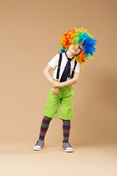Мальчик в клоунском парике танцует и веселится
 - Фото, изображение