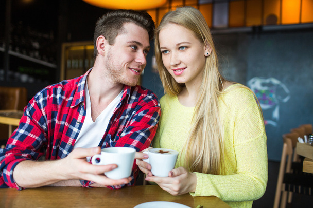 Young man and woman drinking coffee in a restaurant. Young man and woman drinking coffee on a date. man and woman on a date - Photo, image