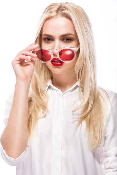 Beautiful blonde girl in pink glasses and shirt. Beauty face. Isolated on white background. - Фото, изображение