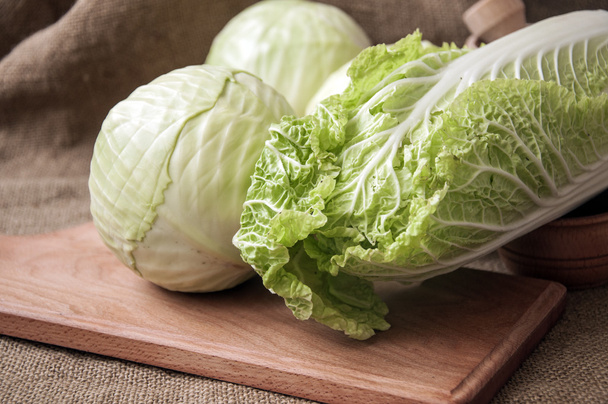cabbage on a wooden board on a background sacking, burlap - Foto, afbeelding