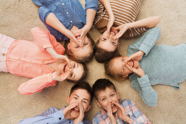 счастливые улыбающиеся дети, лежащие на полу по кругу
 - Фото, изображение