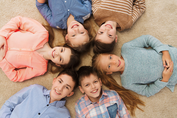 happy smiling children lying on floor in circle - Foto, Imagen