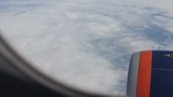 Ala de avião de passageiros. a vista através da janela. acima das nuvens
 - Filmagem, Vídeo