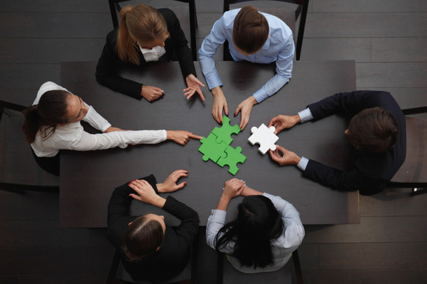 Business people assembling puzzle  - Фото, зображення