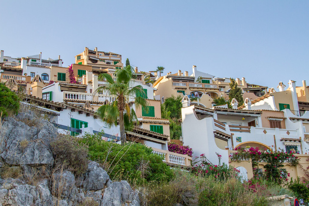 Vista ad angolo basso di edifici residenziali arroccato sul lato di ripida collina in Tropicale Mediterraneo con Sunny Clear Blue Sky
 - Foto, immagini