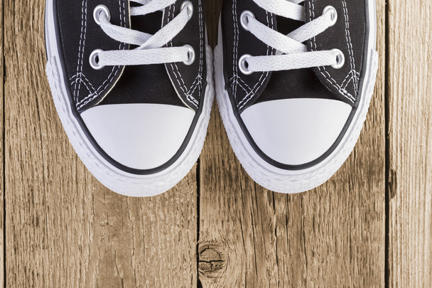 Μαύρα sneakers σε φόντο ξύλου - Φωτογραφία, εικόνα