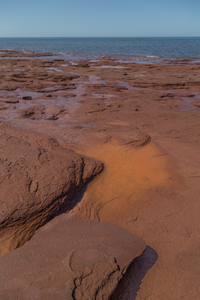 Πορτοκαλί στρωματοειδούς Rock στην παραλία του Cavendish - Φωτογραφία, εικόνα