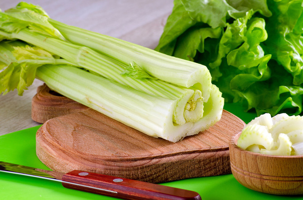 Celery stalks on the kitchen Board and knife - Photo, Image