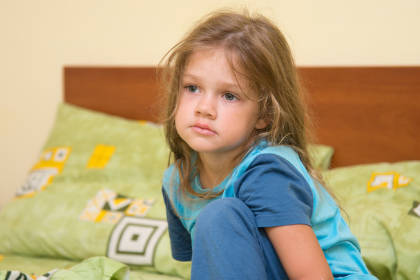 Πέντε ετών λυπημένος υπνηλία κορίτσι ξυπνήσει κάθεται στο κρεβάτι - Φωτογραφία, εικόνα