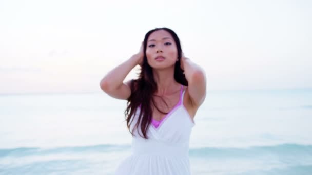 Китаянка в белом платье танцует на пляже
 - Кадры, видео