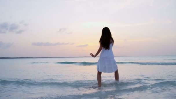 Chiński dziewczynka w białej sukni tańczy na plaży - Materiał filmowy, wideo