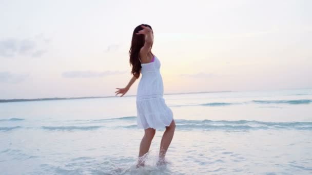 Chica china en vestido blanco bailando en la playa
 - Metraje, vídeo