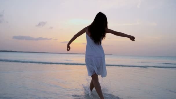 Китайська дівчина в Білій сукні танці на пляжі - Кадри, відео