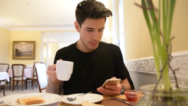 Young Man Drinking Coffee While Looking at Phone - Felvétel, videó