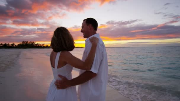 Valkoihoinen pari trooppisella rannalla auringonlaskun aikaan
  - Materiaali, video