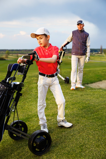 Vater mit Sohn beim Golf - Foto, Bild