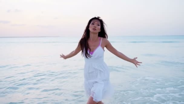 Chiński dziewczynka w białej sukni tańczy na plaży - Materiał filmowy, wideo