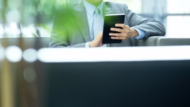 Азиатский бизнесмен в офисном здании с помощью планшета
  - Кадры, видео
