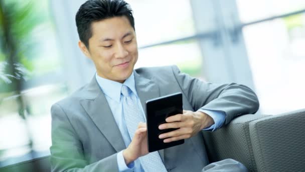Asiatique homme d'affaires dans un immeuble de bureaux en utilisant tablette
  - Séquence, vidéo