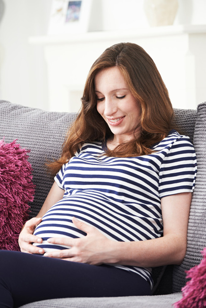 Pregnant Woman Relaxing On Sofa At Home - Foto, Imagen