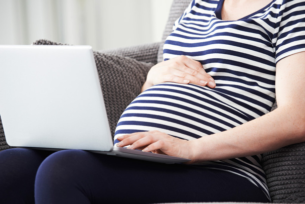 Nahaufnahme von Schwangeren mit Laptop zu Hause - Foto, Bild