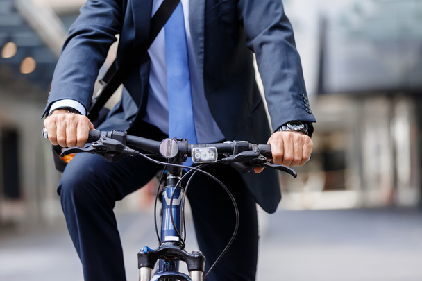 Successful businessman riding bicycle - Фото, зображення