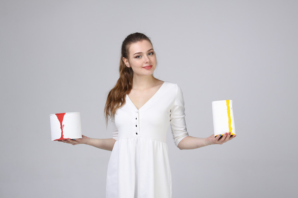 girl in white dress holding paint cans - Foto, Imagem