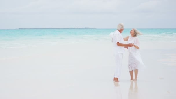 starší pár, kteří požívají dovolená na pláži - Záběry, video