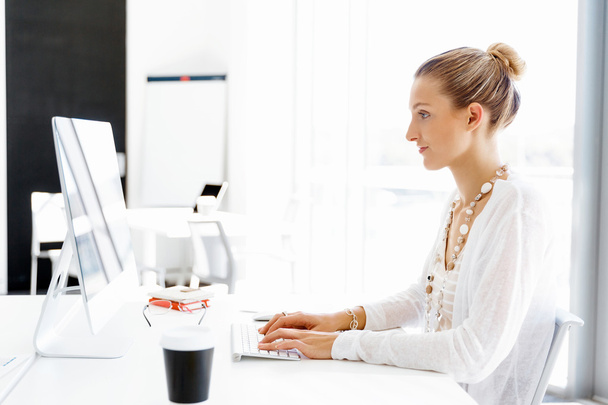 Attractive office worker sitting at desk - Foto, Imagen