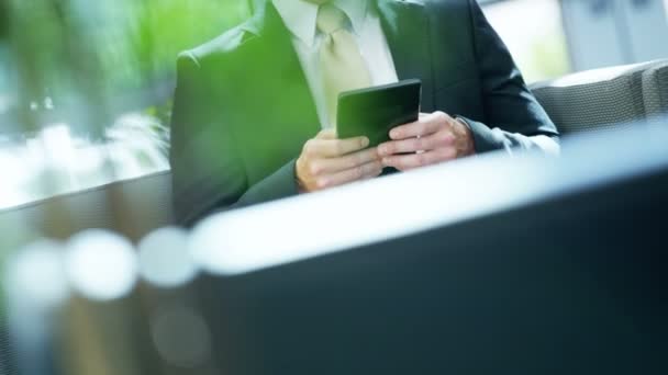 Biznesmen kaukaski w biurowiec przy użyciu tabletu  - Materiał filmowy, wideo