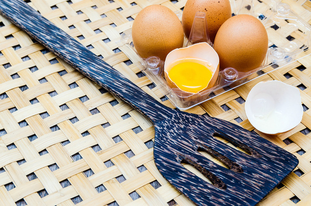 Huevo fresco y pala de sartén sobre bambú
 - Foto, imagen