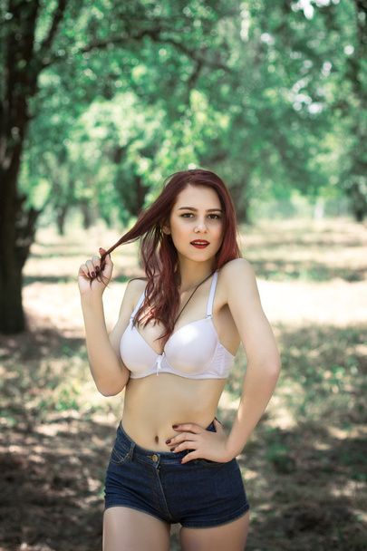 sexy young woman in lingerie in a park - Фото, зображення