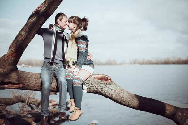 Romantický pár sedící na větvi poblíž vody. - Fotografie, Obrázek