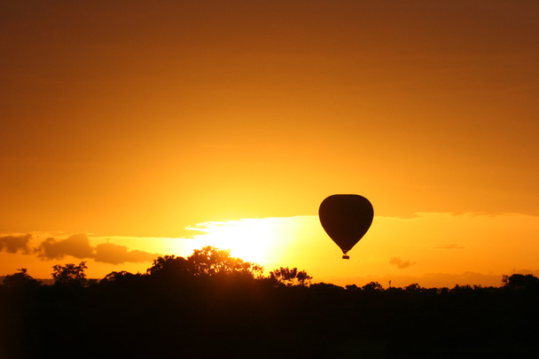Globo de aire caliente volando al amanecer sobre Masai Mara Park, Kenia
 - Foto, imagen