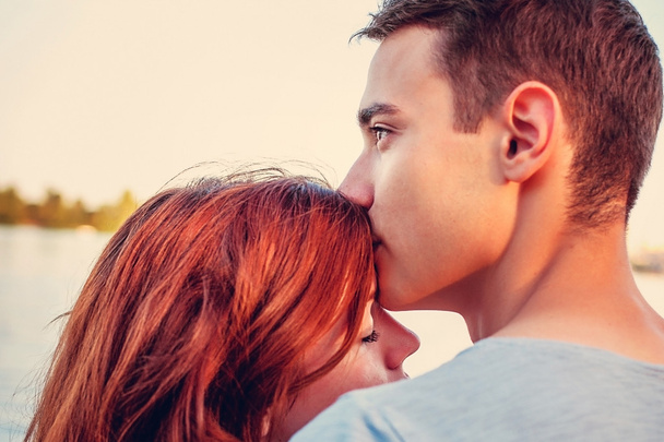 Handsome young man kissing his girlfriend  - Фото, зображення