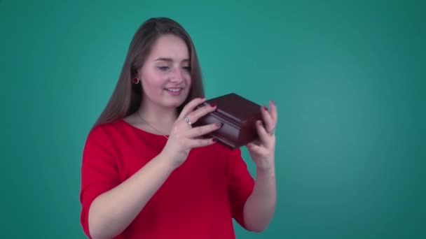 Kaunis nuori tyttö avaa laatikon
 - Materiaali, video