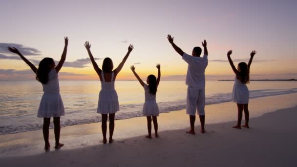 Rodzina kaukaski korzystających wakacje na plaży o zachodzie słońca - Materiał filmowy, wideo