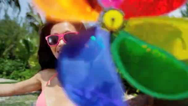 Chica china con molino de viento de juguete en la playa
 - Metraje, vídeo