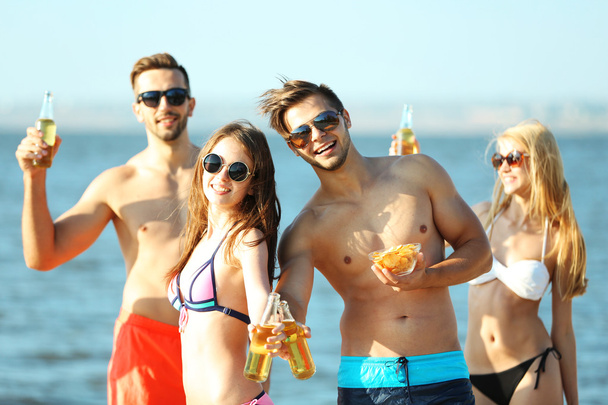 Happy friends drinking beer at beach - Valokuva, kuva