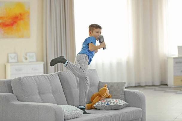 Маленький хлопчик співає з мікрофоном
  - Фото, зображення