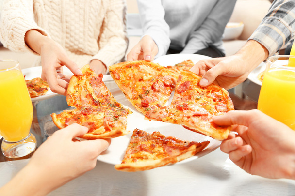 Friends hands holding hot pizza, close up - Fotoğraf, Görsel