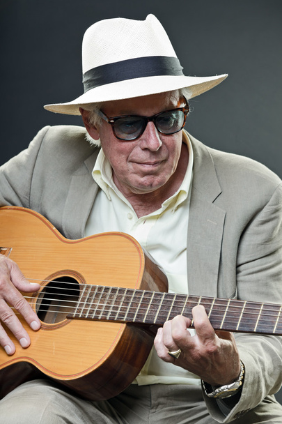 Senior jazz musician with accoustic guitar wearing hat and sunglasses. - Foto, Imagen